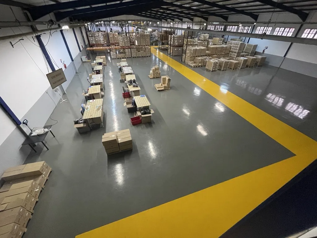 Zone de stockage et d’assemblage : postes de travail et palettes de produits conditionnés.